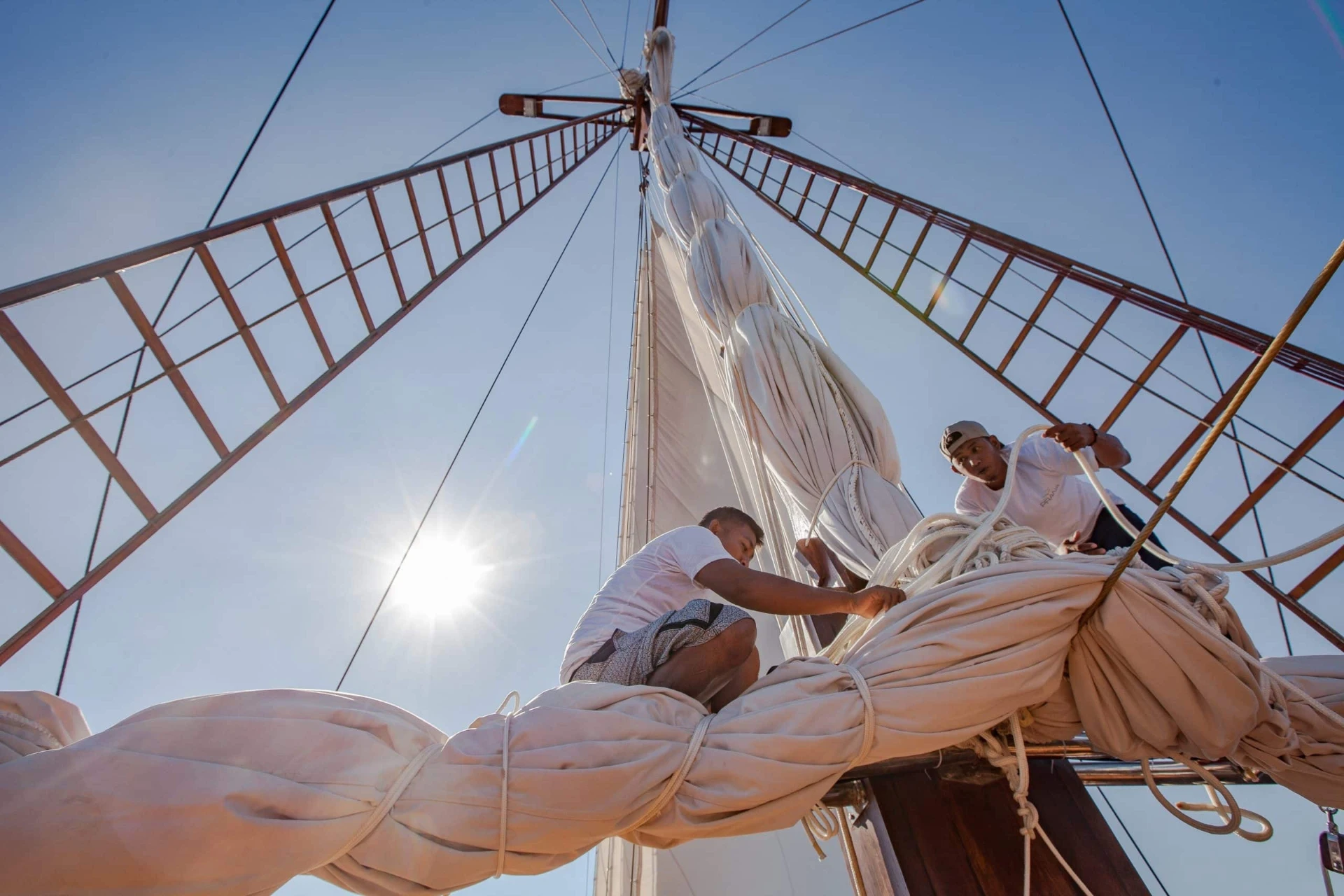 Prana by Atzaró crew hoisting the sails at sunset
