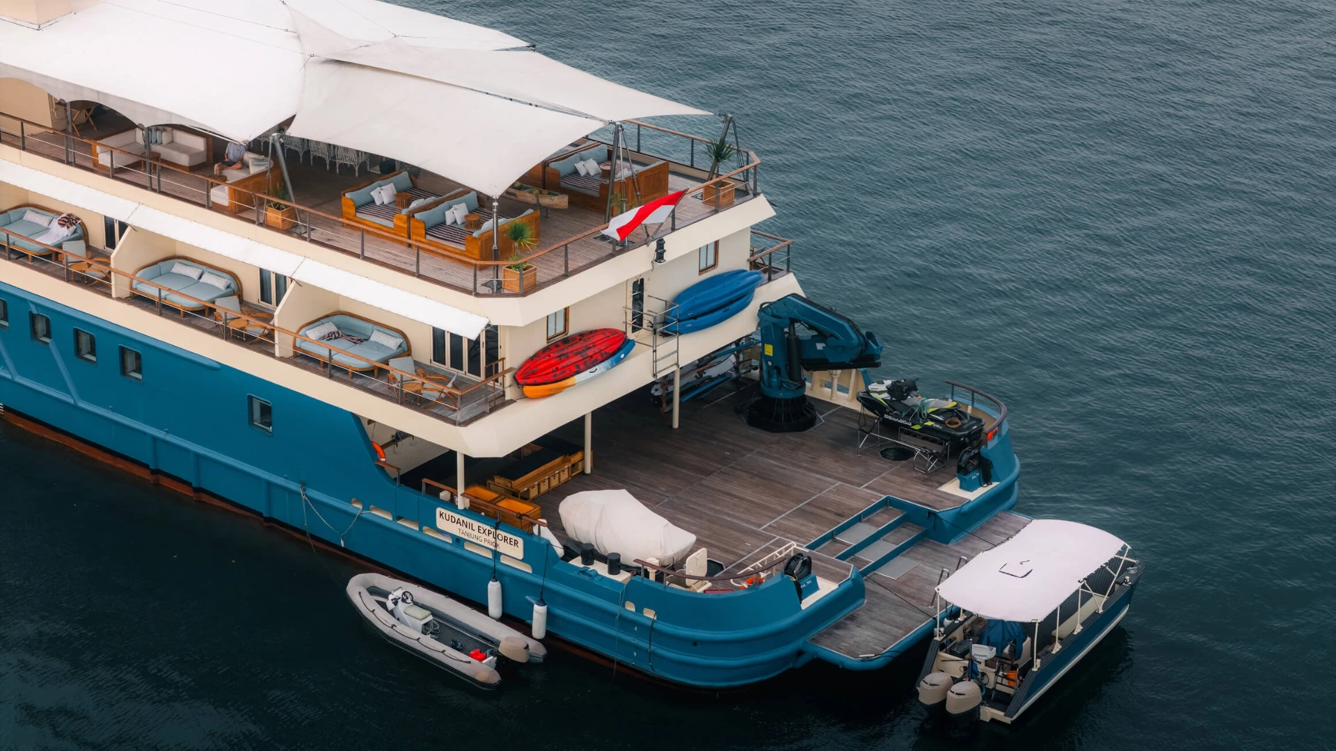 Aerial view of Kudanil Explorer's aft deck showing tenders, jet-ski, kayaks and shaded lounges