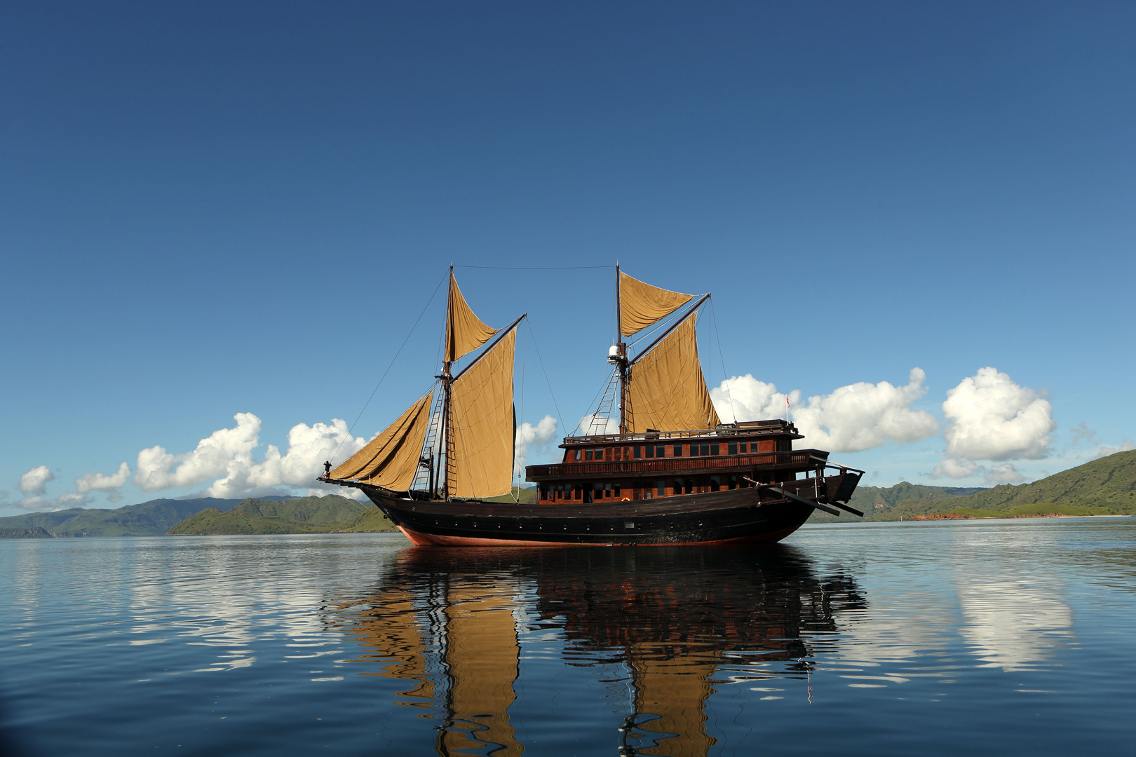 Alila Purnama reflected in glassy calm water at anchor in Indonesia