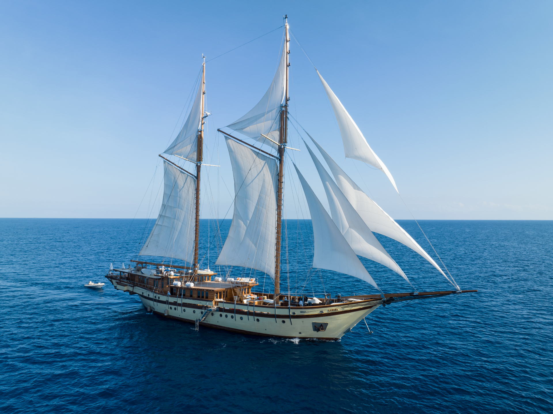 Lamima 65-metre luxury phinisi under full sail on deep blue water — Raja Ampat private yacht charter